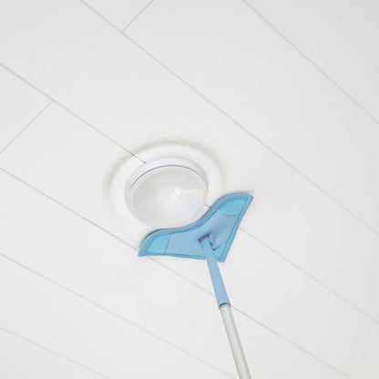 Cleaning tool with a blue head on a white tiled floor