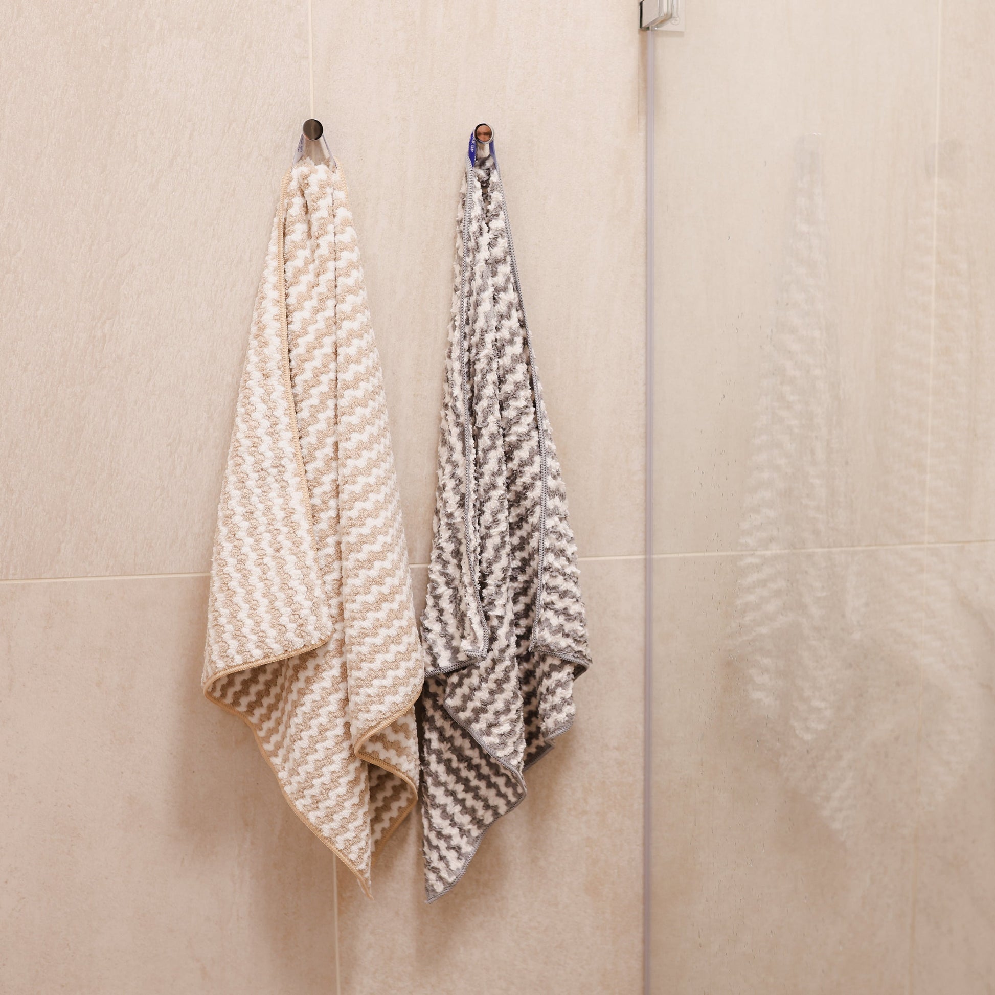 Two towels hanging on a towel rack in a bathroom.
